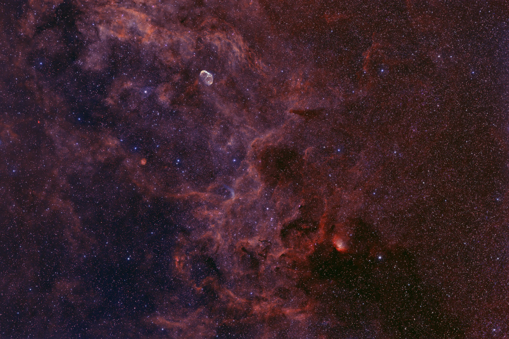 Das Weitwinkelbild zeigt Molekülwolken im Sternbild Schwan (Cygnus) mit dem Emissionsnebel NGC 6888 um einen Wolf-Rayet-Stern sowie Sh2-101, dem Tulpennebel.