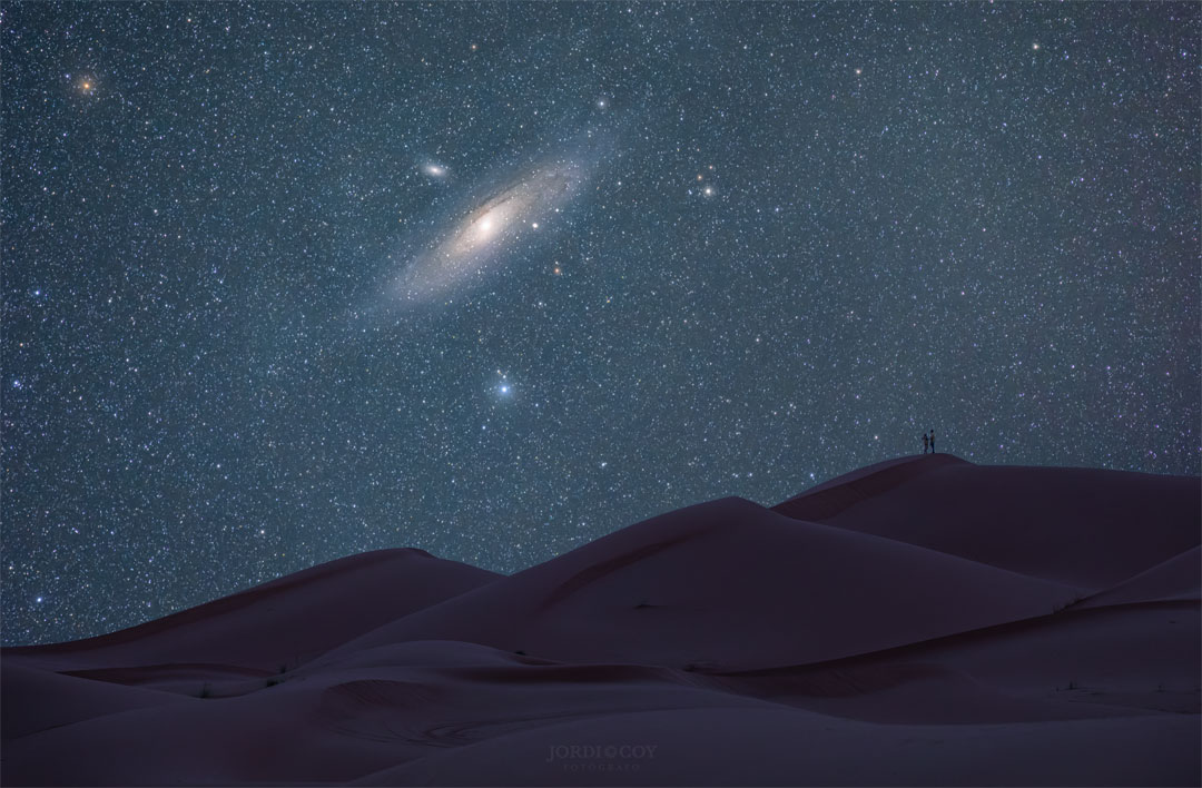 Die Andromedagalaxie Messier 31 am Nachthimmel über den Dünen der Sahara in Marokko