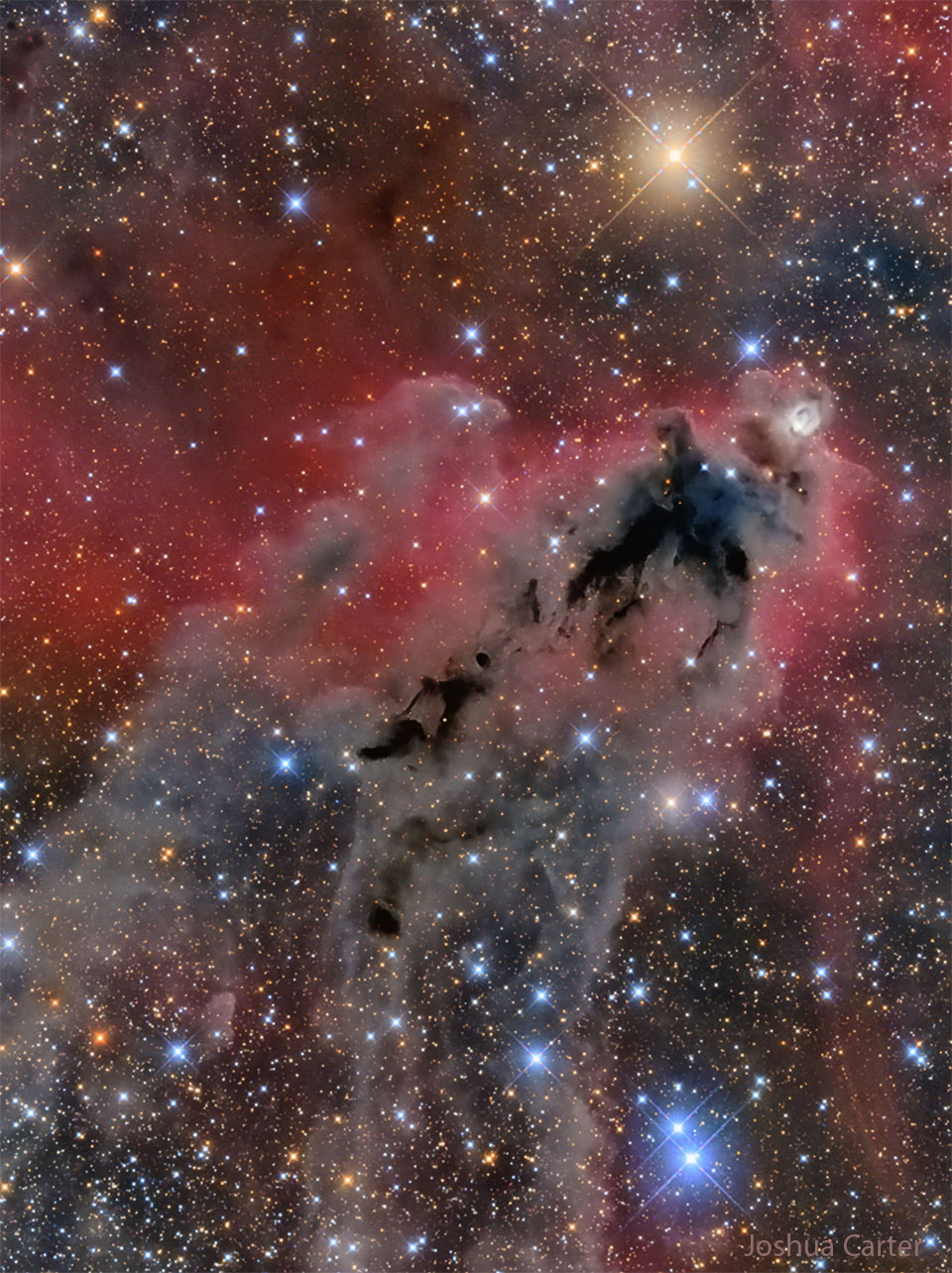 Lynds Dunkler Nebel 1622 im Sternbild Orion ist eine dunle Wolke, die sichtbar ist, weil sie vor einer schwach rot leuchtenden Wasserstoffwolke liegt.