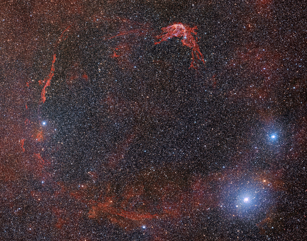 Der Supernovaüberrest RCW 86 leuchtet blassrot und zeichnet sich kaum vom Hintergrund ab.