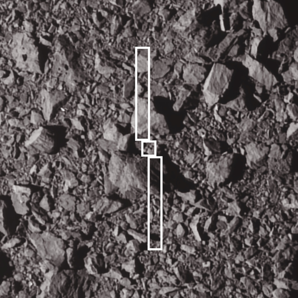 Die Oberfläche des Asteroidenmondes ist mit Steinen und Geröll bedeckt. Zwischen zwei großen Felsbrocken ist der Umriss der Sonde DART mit ihren Solarpaneelen markiert.