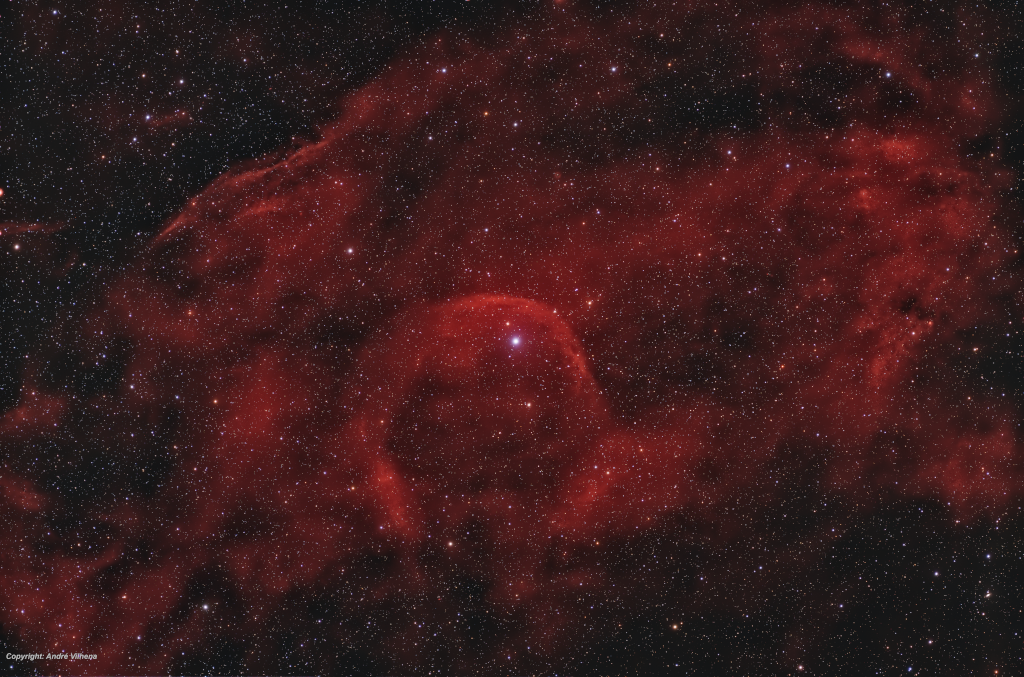 In der Mitte leuchtet ein Stern, der eine rot leuchtende Bugwelle vor sich herschiebt.