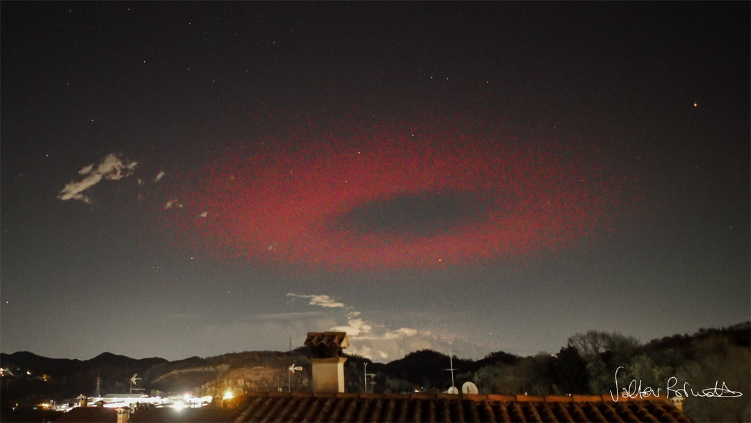 Über einer Landschaft leuchtet am Himmel ein dunkelroter Kreis. Dieser war ein Blitz, und zwar eine so genannte Elfe.