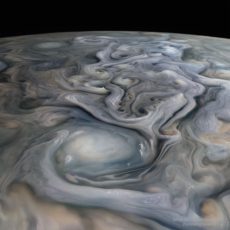 Die Oberfläche des Planeten Jupiter ist von lebhaften Wolkenwirbeln überogen. Vorne in der Mitte ist ein großes weißes Oval, das von Wolken umgeben ist, die Wirbel reichen bis nach hinten zum Rand des Planeten.