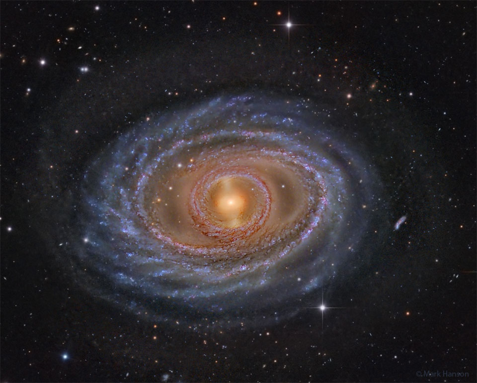 Die Galaxie im Bild ist keine typische Spiralgalaxie, sie hat ums Zentrum, das einen Balken enthält, einen Ring aus Sternen, und weiter außen einen geflochten wirkenden Kranz aus Sternansammlungen.