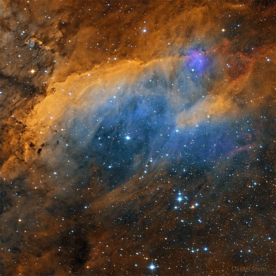 IC 4628 im Bild wird auch als Garnelennebel oder Gum 56 bezeichnet. Der Sternenhintergrund ist von orange und blau leuchtenden Nebelschwaden überzogen.