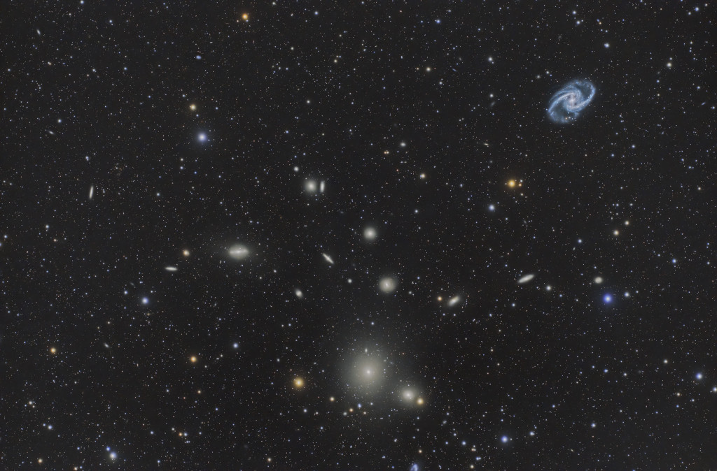 Im Bild sind Galaxien des Fornax-Galaxienhaufens verteilt, die markantesten sind eine elliptische Galaxie unten in der Mitte sowie eine Balkenspiralgalaxie rechts oben.