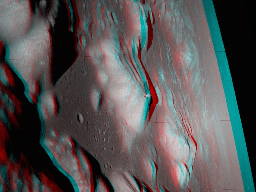 Das Bild zeigt den Erdmond aus der Nähe, der Blick fällt seitlich darauf, rechts hinten ist der Mondrand und dahinter das Weltall.
Das Bild ist eine rot-cyanfarbige Anaglyphe. Mit farbigen Brillen wirkt es dreidimensional.
