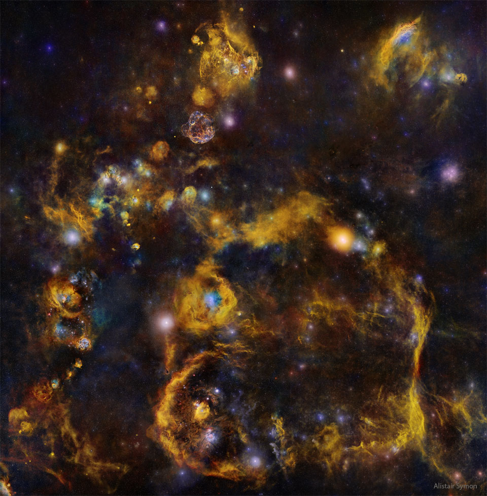 Das sehr detailreiche Bild des Nachthimmels zeigt viele Sterne und Nebel, die scheinbar durch schwache orangefarbene Fäden verbunden sind.