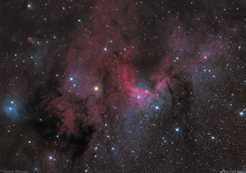 Rechts unten ist das Bild sternklar, links oben ist es voller dunkler und dunkelroter Nebel mit wenigen hellen Sternen. In der MItte sind hellrote Ranken.