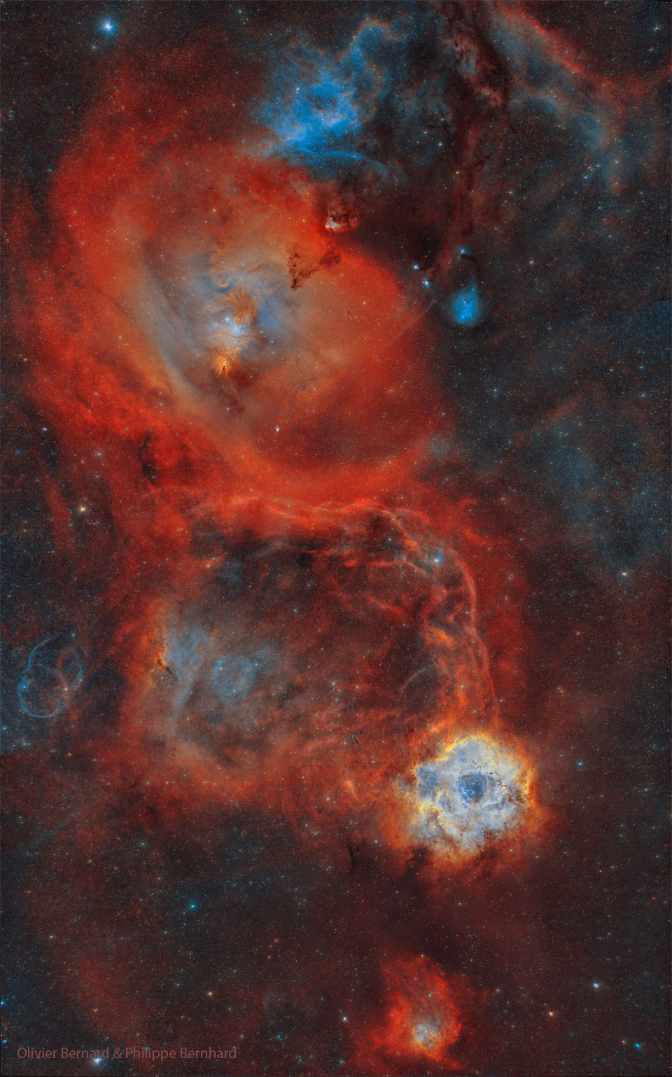 Das Bild zeigt ein belebtes Sternfeld mit mehreren großen roten Nebeln. Der Rosettennebel ist rechts unten zu sehen. Der Nebel um den Kegelnebel ist größer und links oben zu sehen.