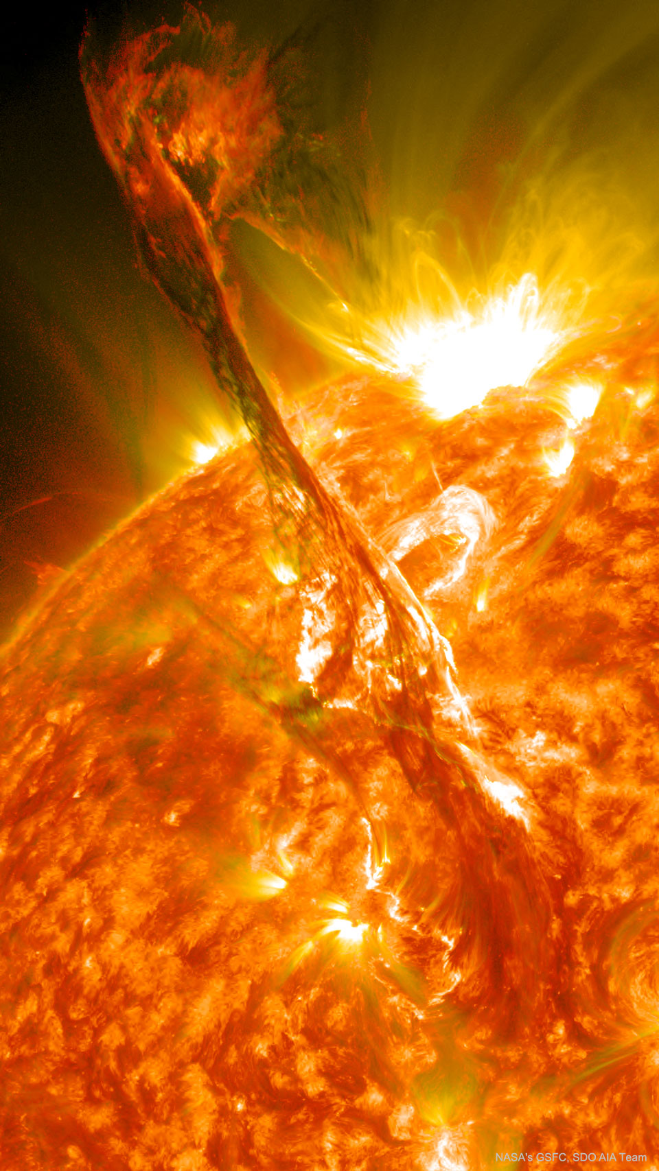 Die Sonnenoberfläche ist in Falschfarben dargestellt, das Bild zeigt einen Ausschnitt mit hellen aktiven Regionen. Von unten wölbt sich eine Sonnenfackel - ein Filament - hoch über die Sonnenoberfläche.