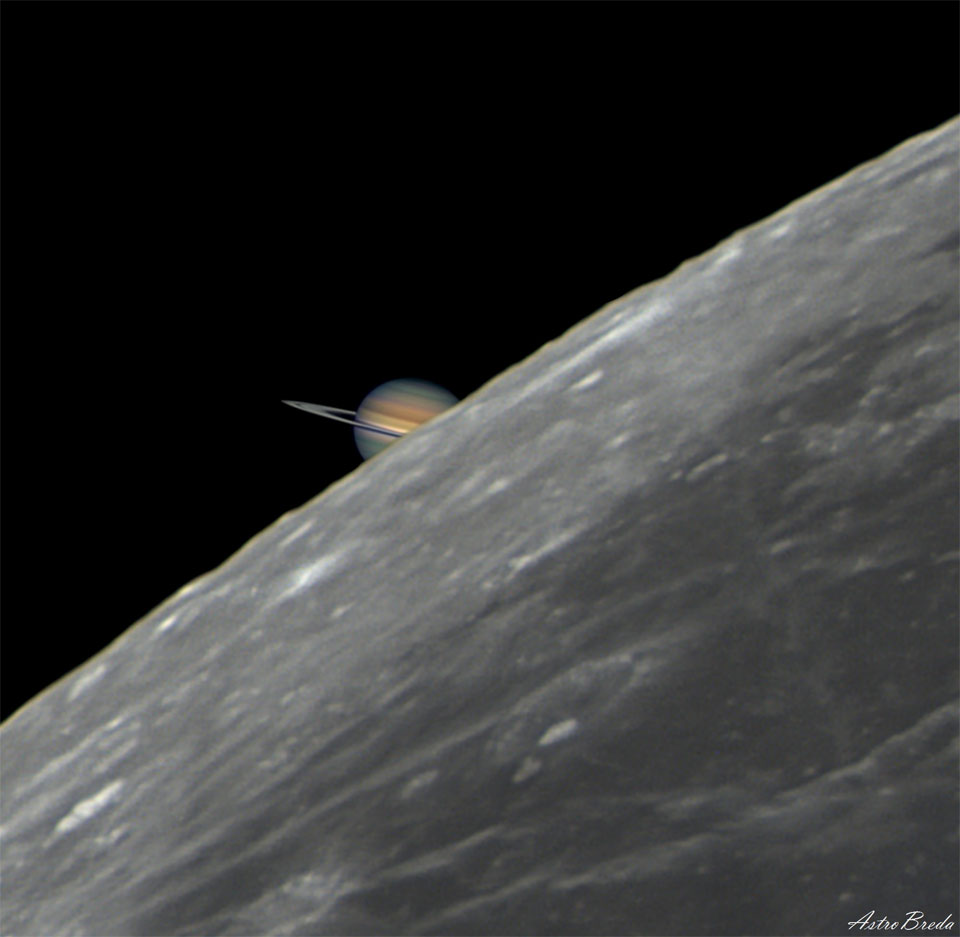 Hinter dem grauen Mond rechts unten taucht in der Bildmitte der Saturn auf. Im Bild wirkt er farbig, seine Ringe sind fast von der Seite zu sehen.