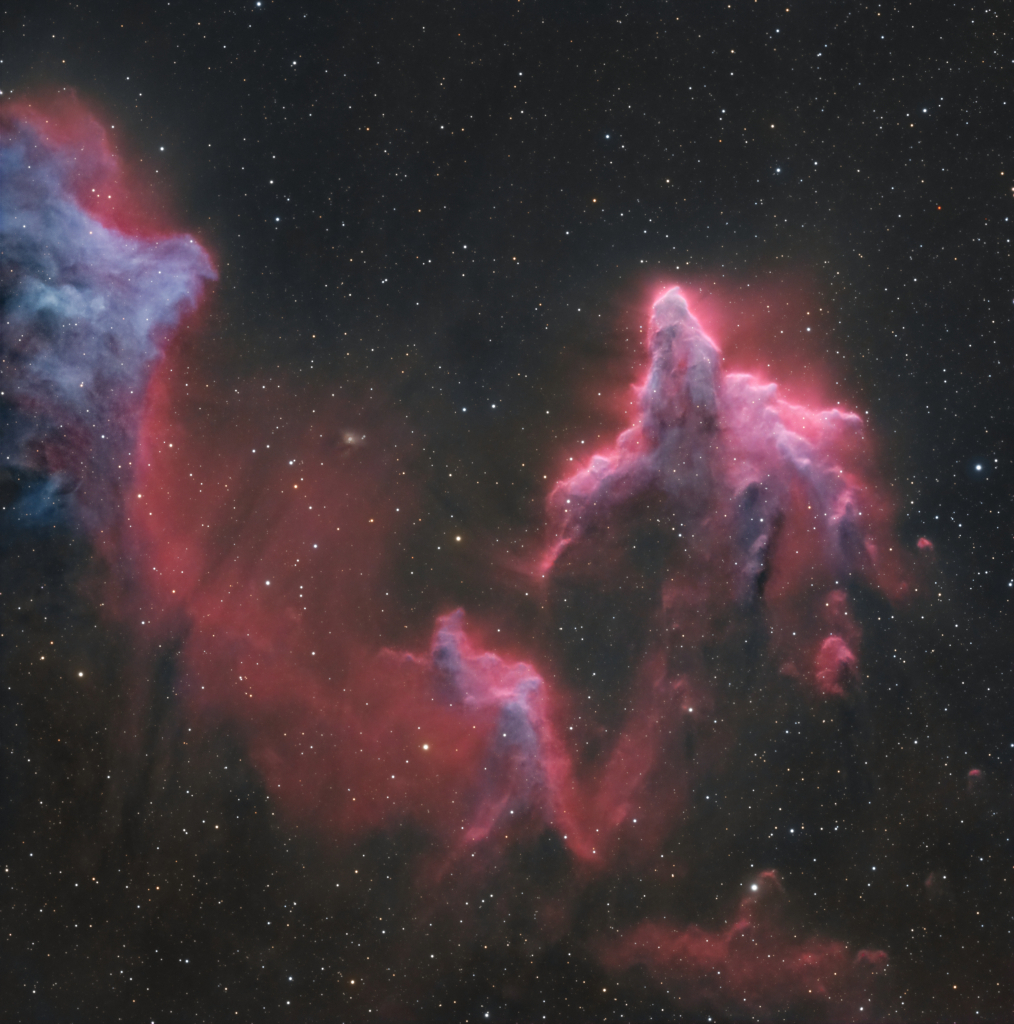 Vor einem dunklen, schwach gestirnten Himmel türmen sich Nebelgebirge auf, die von einem rosaroten Leuchten umgeben sind.