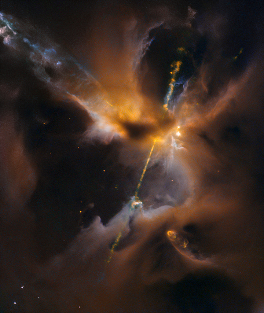 In der Mitte der teils dunklen, teils orange-braunen Nebelwolken leuchtet ein helles Objekt. Links daneben strömen zwei Strahlen hinter einer dunklen Wolke hervor, einer nach oben, der andere nach unten.