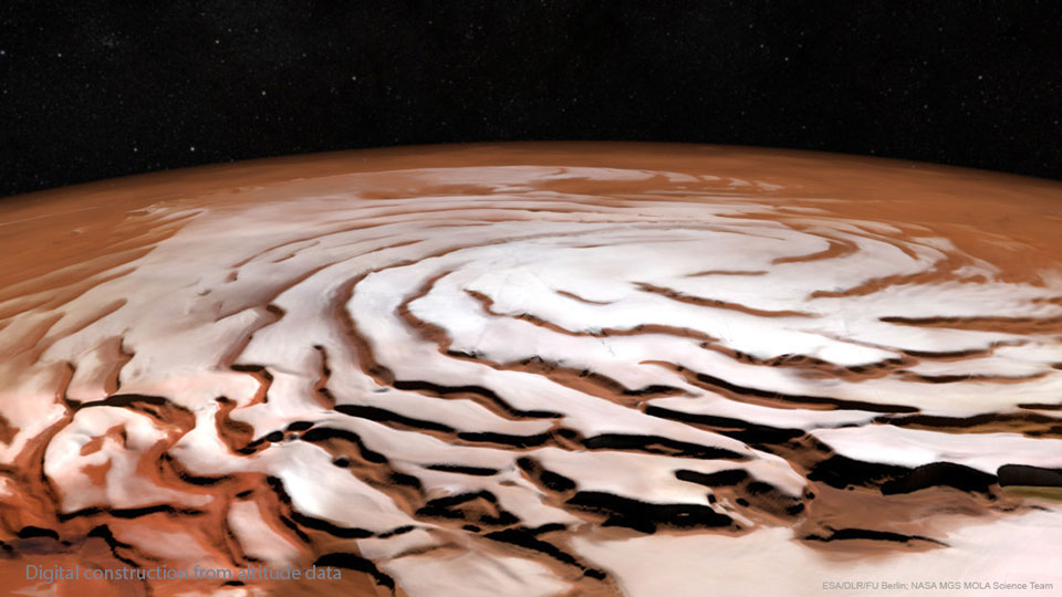 Der Nordpol des Mars ist von einer weißen Struktur umgeben, in der spiralförmige Gräben verlaufen.