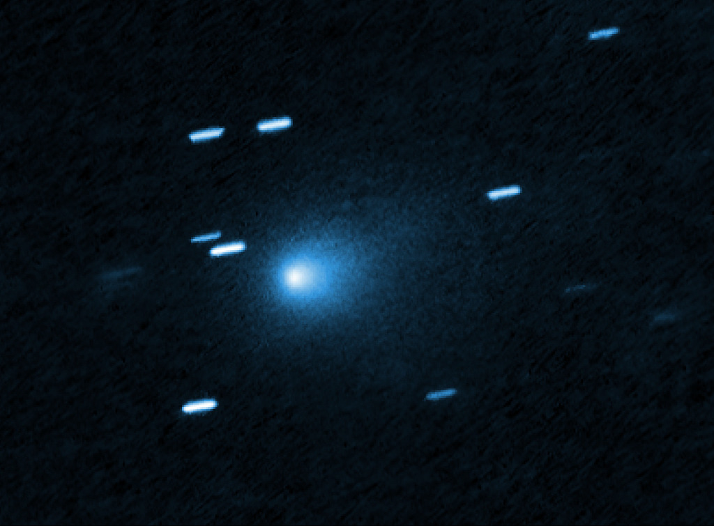 Zwischen den kurzen Strichen, die von Sternen gezogen wurden, schimmert die blaue Koma eines interstellaren Kometen.