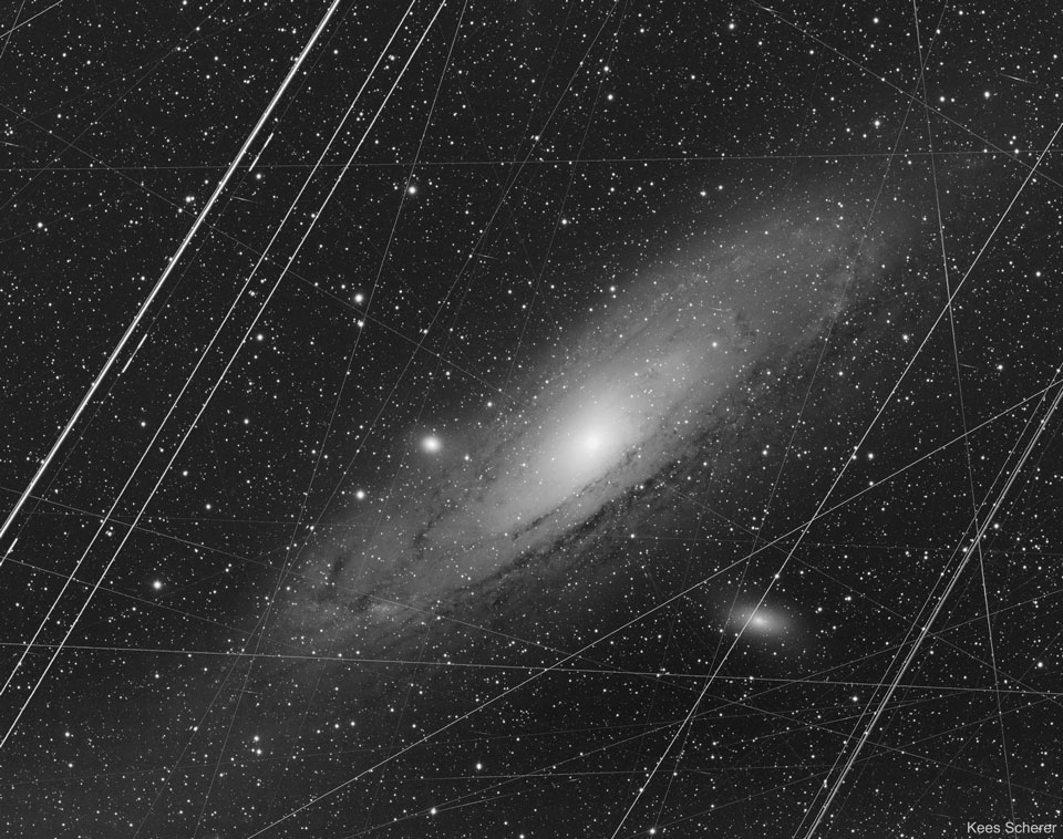 Diese Spiralgalaxie nimmt einen Großteil des Bildes ein. Viele gerade Linien durchziehen sie. Auf dem alternativen Bild wurden die geraden Linien entfernt.