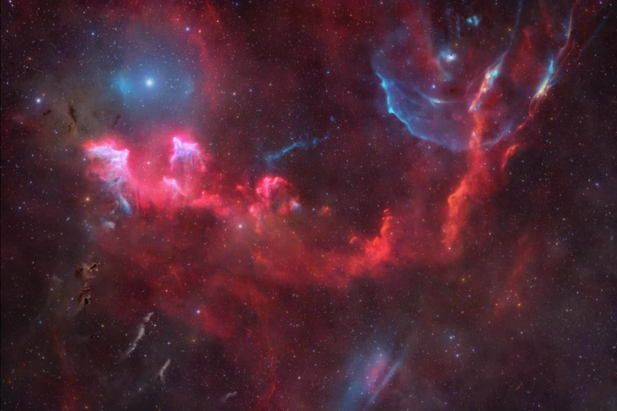 Der Himmel ist von Sternen übersät. Helle Flecken von Emissionsnebeln ziehen sich über den Äquator des Bildes. Auch Bögen und Flecken aus ionisiertem Sauerstoff sind zu sehen.